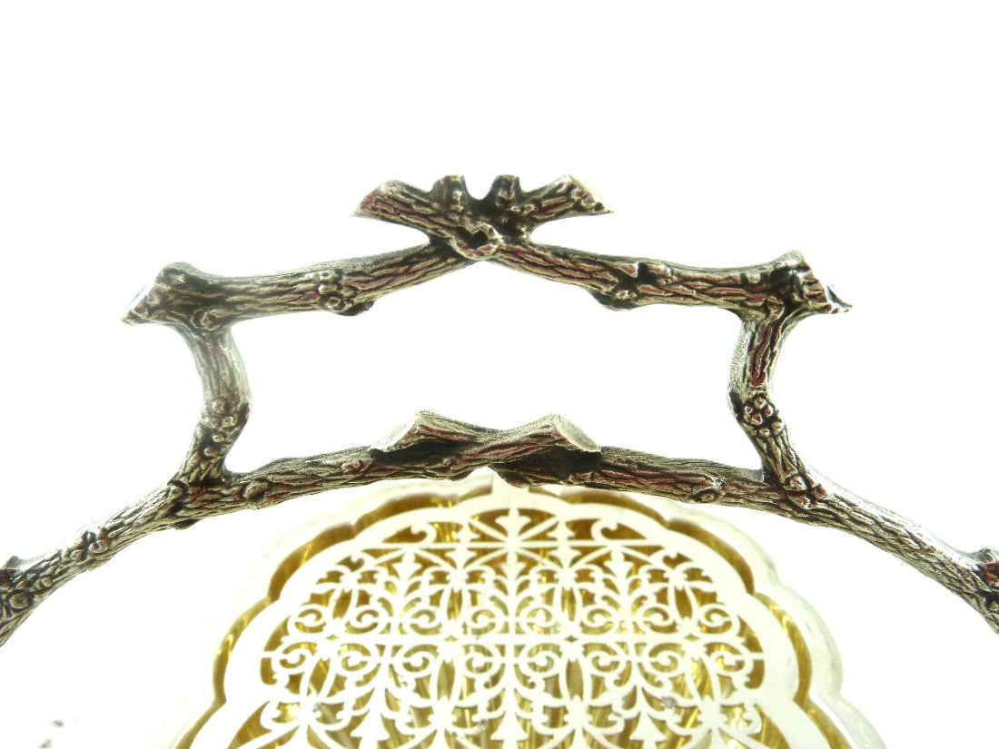 Close up view of naturalistic branch handles on English silver plate biscuit box  